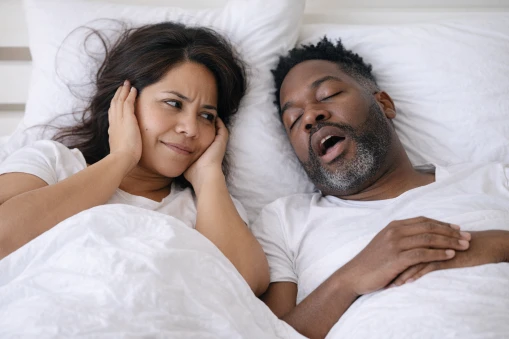 couple in bed man snoring with sleep apnea
